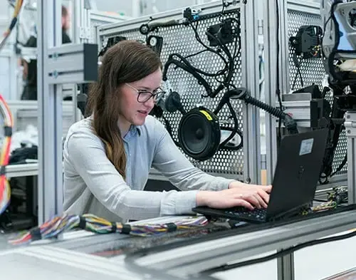 Engineers monitoring robotic arms and dashboards in a smart industrial automation setup.